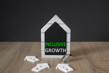 Concept green words Inclusive growth on a black board in the shape of a house. Beautiful wooden...