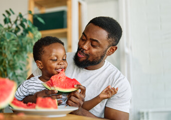 child family kitchen food boy son father watermelon fruit slice summer organic meal fun preparing healthy diet eating home black