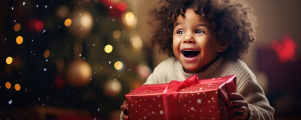 Obraz na płótnie Canvas Happy and surprised boy while opening christmas present with amazing background. Christmas time concept.
