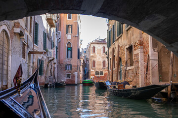 Riding a gondola under a bridge in Venice, Italy © Maureen