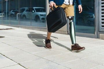 Businessman with artificial leg carrying briefcase on urban sidewalk, reflecting resilience.