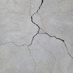 Long winding cracks in the wall. Cracked concrete surface covered with gray cement mortar.Texture background. Repair, construction of buildings, shrinkage