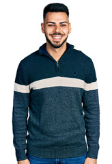 Young hispanic man with beard wearing casual winter sweater with a happy and cool smile on face....