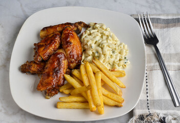 chicken wings  served with french fries and  macaron i salad
