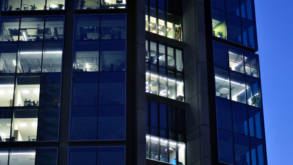 Fragment of the glass facade of a modern corporate building at night. Modern glass office  in city....