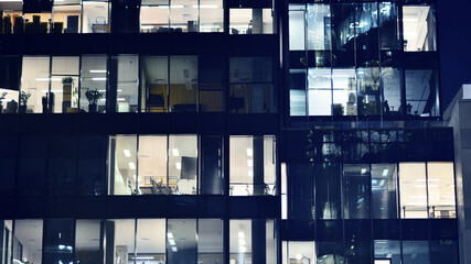 Fragment of the glass facade of a modern corporate building at night. Modern glass office  in city. 