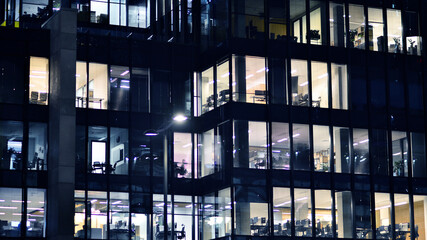 Fragment of the glass facade of a modern corporate building at night. Modern glass office  in city. 