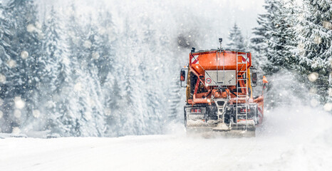 Snow plow on highway salting road . Orange truck deicing street. Maintenance winter gritter vehicle...
