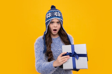Teenager kid with present box. Teen girl giving birthday gift. Present, greeting and gifting concept. Surprised teenager girl.