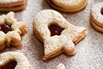 Bell shaped Linzer Christmas cookie filled with strawberry marmalade and dusted with sugar
