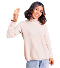 Young beautiful mixed race woman wearing winter turtleneck sweater showing and pointing up with fingers number four while smiling confident and happy.