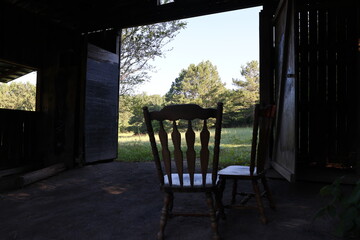 Fototapeta na wymiar Barn and Rocking Chairs in field 