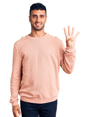 Naklejka premium Young hispanic man wearing casual clothes showing and pointing up with fingers number four while smiling confident and happy.