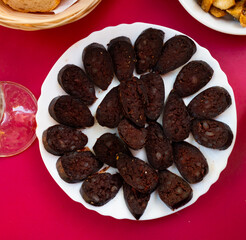 Sliced pieces of burgos blood sausage served on platter..