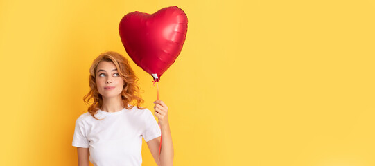 pondering redhead girl with love heart balloon. be my valentine. Beautiful woman isolated face...