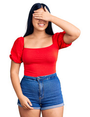 Obraz premium Young beautiful asian girl wearing casual clothes smiling and laughing with hand on face covering eyes for surprise. blind concept.