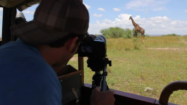 Man taking photos of beautiful giraffe in Kenya, Africa