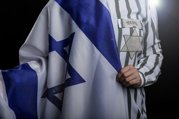 Jewish female prisoner with flag of Israel on dark background, closeup. International Holocaust...
