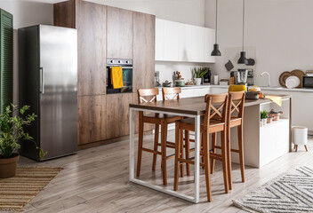 Interior of light kitchen with modern appliances on wooden table