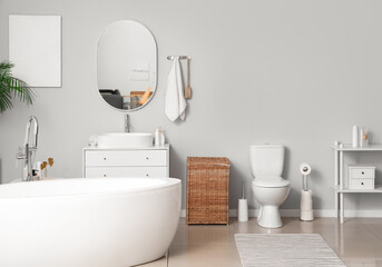 Interior of light bathroom with bathtub and toilet bowl