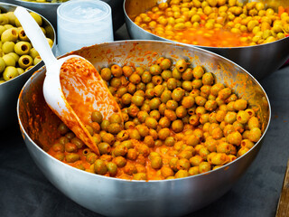 Containers filled with pitted green Spanish olives marinated in spices