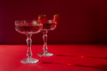 Two glasses of rose sparkling wine on red background romantic valentine's day concept