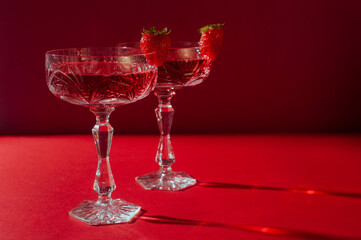 Two glasses of rose sparkling wine on red background romantic valentine's day concept