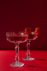 Two glasses of rose sparkling wine on red background romantic valentine's day concept