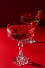 Two glasses of rose sparkling wine on red background romantic valentine's day concept