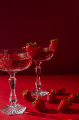 Obraz premium Two&nbsp;glasses&nbsp;of&nbsp;rose&nbsp;sparkling&nbsp;wine&nbsp;on&nbsp;red&nbsp;background&nbsp;romantic&nbsp;valentine's&nbsp;day&nbsp;concept