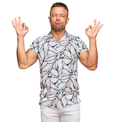 Naklejka premium Handsome muscle man wearing casual clothes relax and smiling with eyes closed doing meditation gesture with fingers. yoga concept.