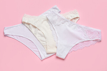Set of cotton female panties on pink background - obrazy, fototapety, plakaty
