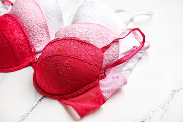 Set of stylish bras on light background, closeup