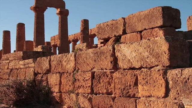 agrigento sicily italy ancient temple of juno pillars with large bricks brickwork stacked in foreground pan left to right ending on bricks