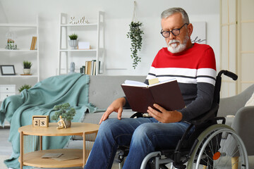 Senior man in wheelchair reading book at home