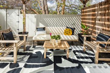Table and chairs on a patio with the sunlight coming through the fence