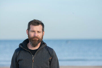 Portrait of man standing on sandy beach. bearded man at beach