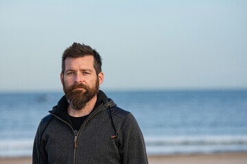 Portrait of man standing on sandy beach. bearded man at beach