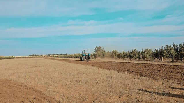 Tractor cultivating field, Farmer in tractor preparing farmland, Ploughing a field
