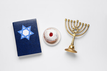 Hanukkah composition with Torah, menorah and donut on white background