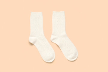 White knitted socks on beige background