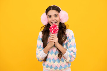 Teenager girl eating sugar lollypop. Candy and sweets for kids. Child eat lollipop popsicle over...