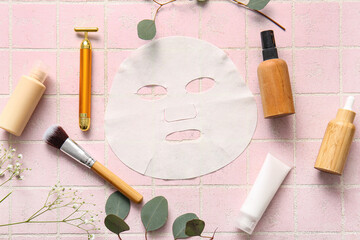 Facial sheet mask with different cosmetic products, gypsophila flowers and eucalyptus on pink tile...