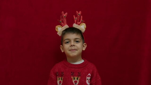 No idea. Helpless hand gesture of cute child in christmas ugly sweater and with reindeer ears and horns. having no ideas, feeling uncertain. High quality 4k footage