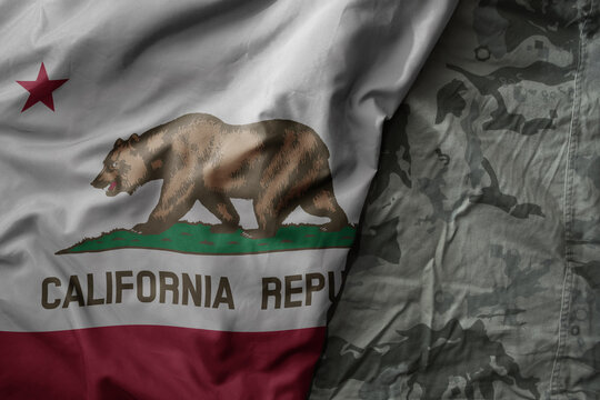 waving flag of california state on the old khaki texture background. military concept.