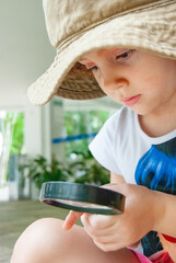 Girl with magnifying glass playing detective and investigating clues