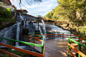 Tourists on outdoor adventure and natural waterfall Ducha de Plata (silver fall) in the Campos do Jordao mountains Serra da Mantigueira