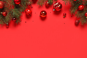 Red Christmas balls and fir branches on color background