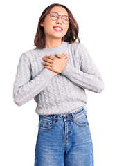 Young beautiful chinese girl wearing casual clothes smiling with hands on chest with closed eyes and grateful gesture on face. health concept.