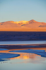 View of colorful mountain peak of Dali Mountains and laguna Colorada, orange reflection in water...